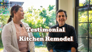 Dan and Sonia Elks sharing their kitchen remodel testimonial sitting in front of a window overlooking their backyard, featuring a 'Testimonial Kitchen Remodel' text overlay and the Lemon Remodeling and Diamond Certified logos.