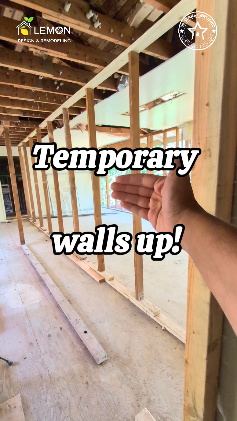 Two parallel temporary framing walls supporting overlapping ceiling joists during a load-bearing wall removal project by Lemon Remodeling.
